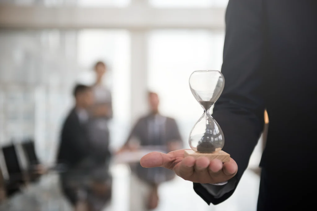 Man holding an hourglass – symbolising the urgency and value of time for effective leadership planning.