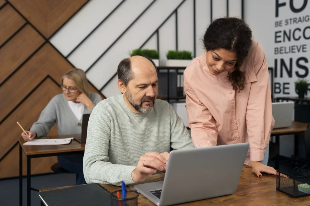 School leaders assisting in a classroom setting with laptops – illustrating the academic and supervisory responsibilities they juggle.